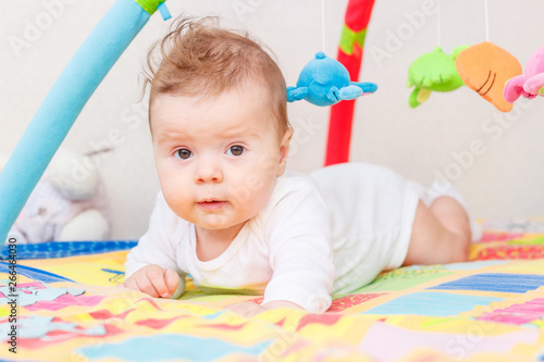 Playing little child on the colored mat for developing