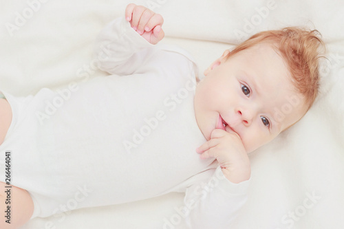 Happy child on the white blanket, blurred background