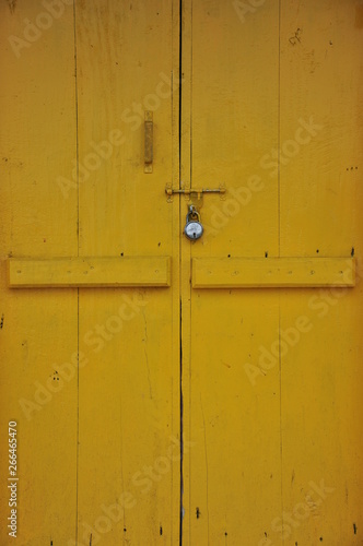 old yellow wooden door with lock