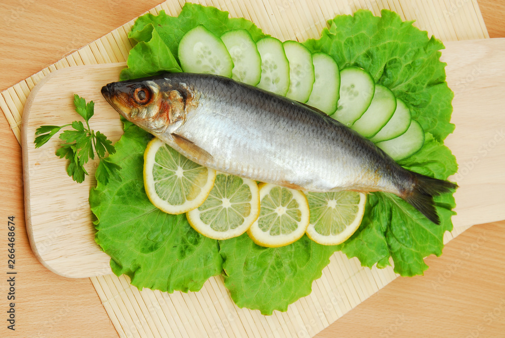 Plate with sardines tomatoes and aromatic herbs on gray isolated background Plate with sardines tomatoes and aromatic herbs on gray isolated background