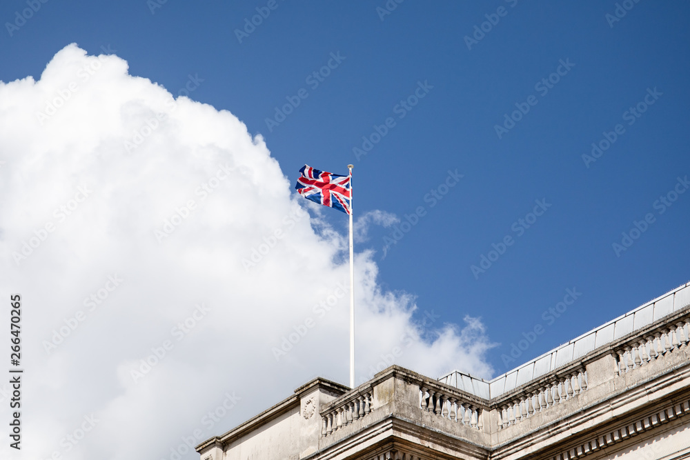 British flag on a mast, cloudy sky in background