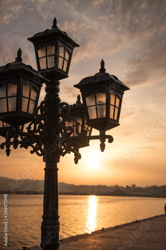 poetic vintage streetlight in a sunset in front of the sea © Alvaro