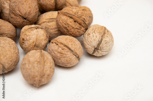 walnut stands a lot on the table. greek nut and coffee beans on a bamboo mat, on a white background.