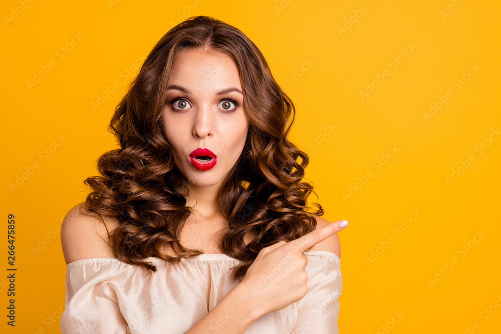 Obraz premium Close-up portrait of her she nice attractive lovely charming winsome stunning amazed wavy-haired lady showing forefinger aside advert sale discount isolated over bright vivid shine yellow background