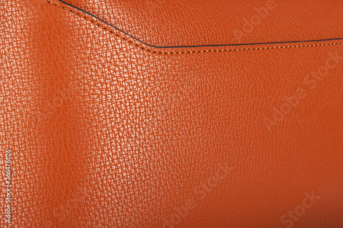 A piece of monochrome orange leather with neat stitching