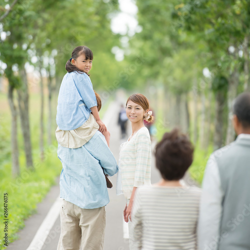 一本道で肩車をする親子と祖父母 © ohayou!