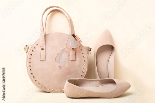 Beautiful elegant classic spring suede shoes, fashionable women's handbag and accessory on beige background.