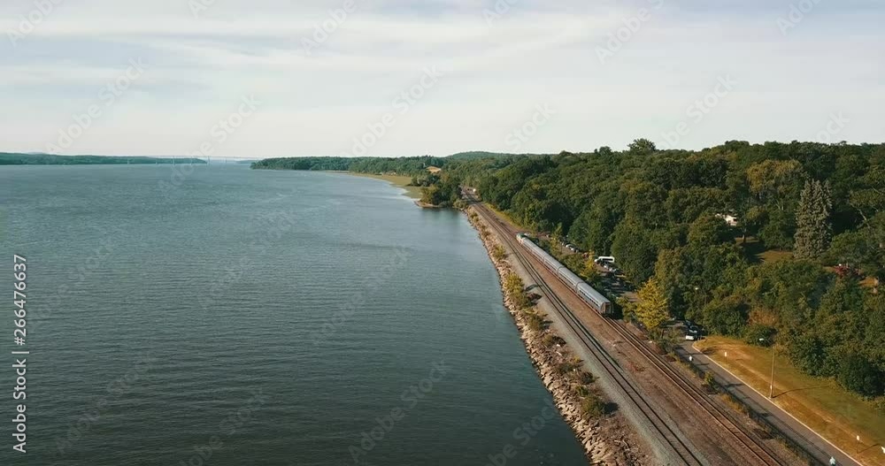This is a majestic aerial drone shot of a train leaving a stop in upstate New York. This is a majestic aerial drone shot of a train leaving a stop in upstate New York.