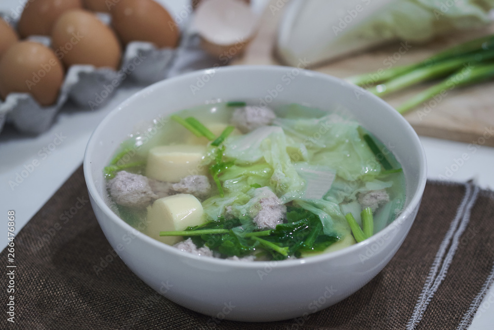 Clear soup with vegetables egg tofu and minced pork on table Clear soup with vegetables egg tofu and minced pork on table
