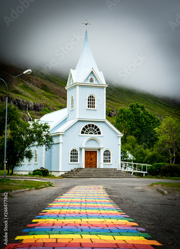 White church with rainbow path in Iceland