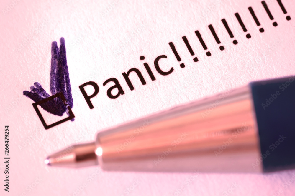 Questionnaire – blue pen and the inscription PANIC with check mark on the white paper Questionnaire – blue pen and the inscription PANIC with check mark on the white paper