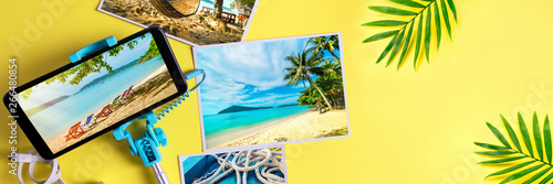 Flat lay monopod with a smartphone and photos on a yellow background Travel concept Banner photo