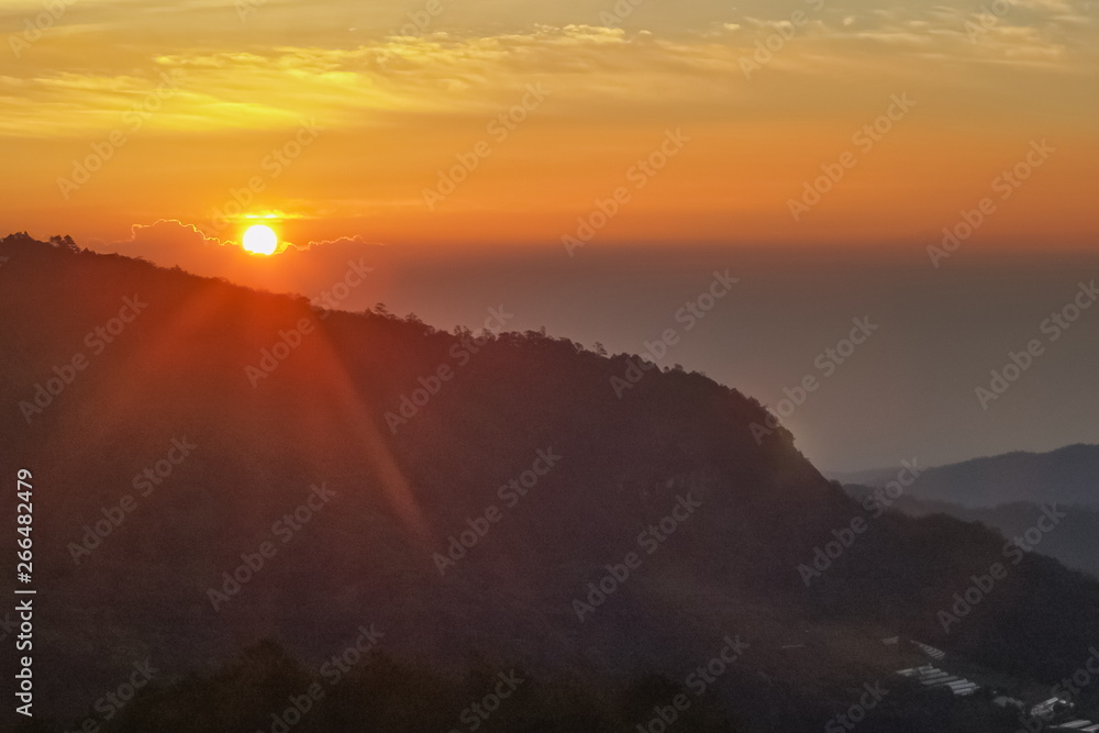 sunrise at Doi Inthanon, mountain view misty morning of sunrise above top hills with red sky background, Ban Khun Wang, unseen Doi Inthanon, Chiang Mai, Thailand.