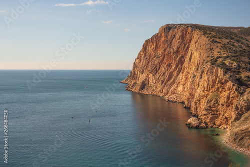 Beautiful nature landscape with sea and high rocky orange mountains, summer travel and freedom concept