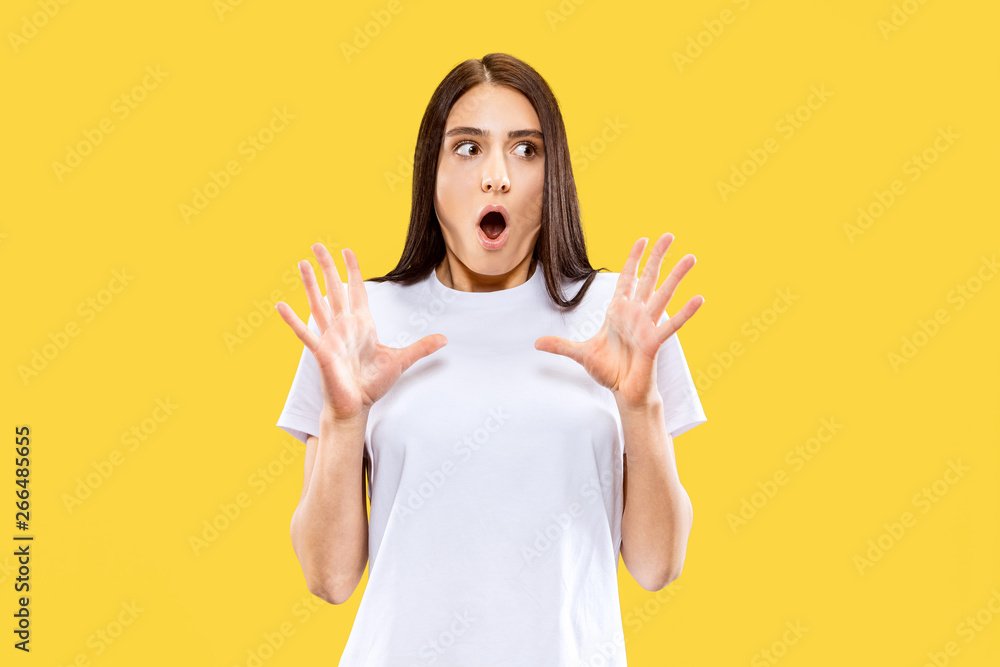 Astonished and wondered girl. Beautiful female half-length portrait isolated on yellow studio background. Young smiling woman. Negative space. Facial expression, human emotions concept. Astonished and wondered girl. Beautiful female half-length portrait isolated on yellow studio background. Young smiling woman. Negative space. Facial expression, human emotions concept.