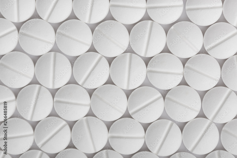 White pills background. Tablets pattern macro.