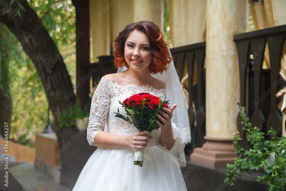 beautiful young bride in a white dress, holding a bouquet in her hands, smiling. Wedding beautiful young bride in a white dress, holding a bouquet in her hands, smiling. Wedding