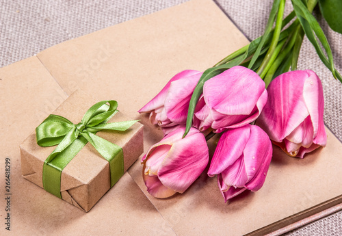 Gift with bow and pink tulips. Gift box
