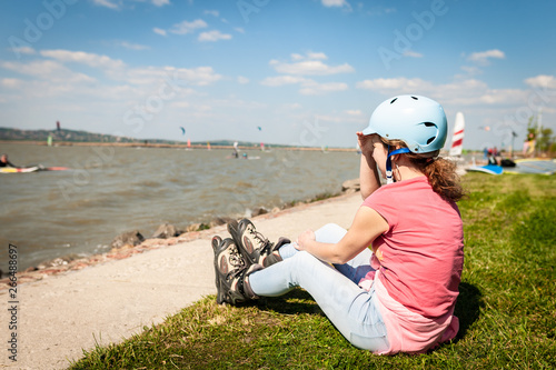 Close up picture of a woman wear inline roller blades near a strand of a lake