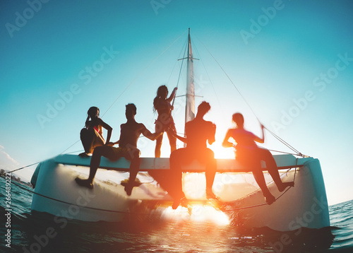 Fototapete Silhouette of young friends chilling in catamaran boat - Group of people making