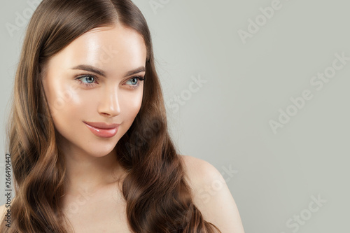Beautiful female face. Healthy model with clear skin and long brown hair. Skincare and haircare concept