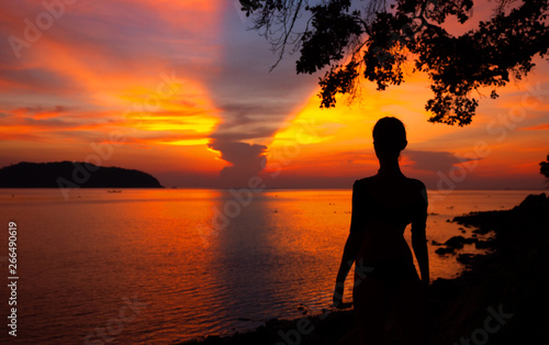 Woman looking at sunrise on the sea © Glebstock