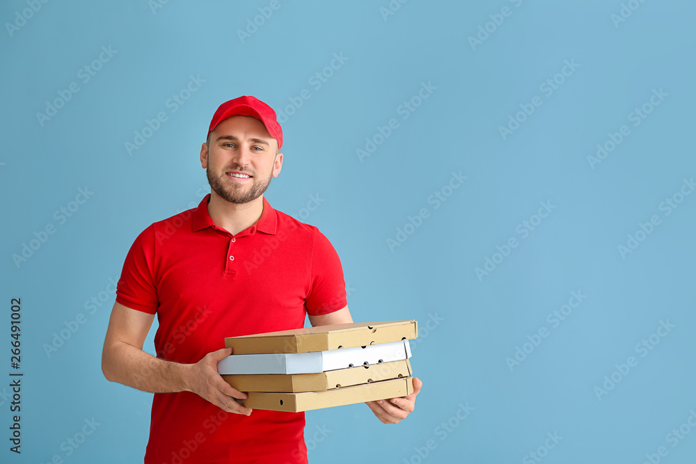 Handsome delivery man with pizza boxes on color background Handsome delivery man with pizza boxes on color background