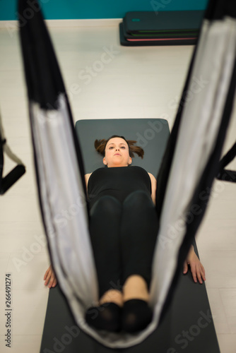 Pregnant woman does aeropilates exercises. The focus is on her face of concetration