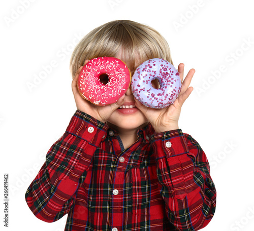 Happy little boy with tasty donuts on white background