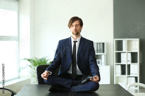 Businessman practicing yoga in office