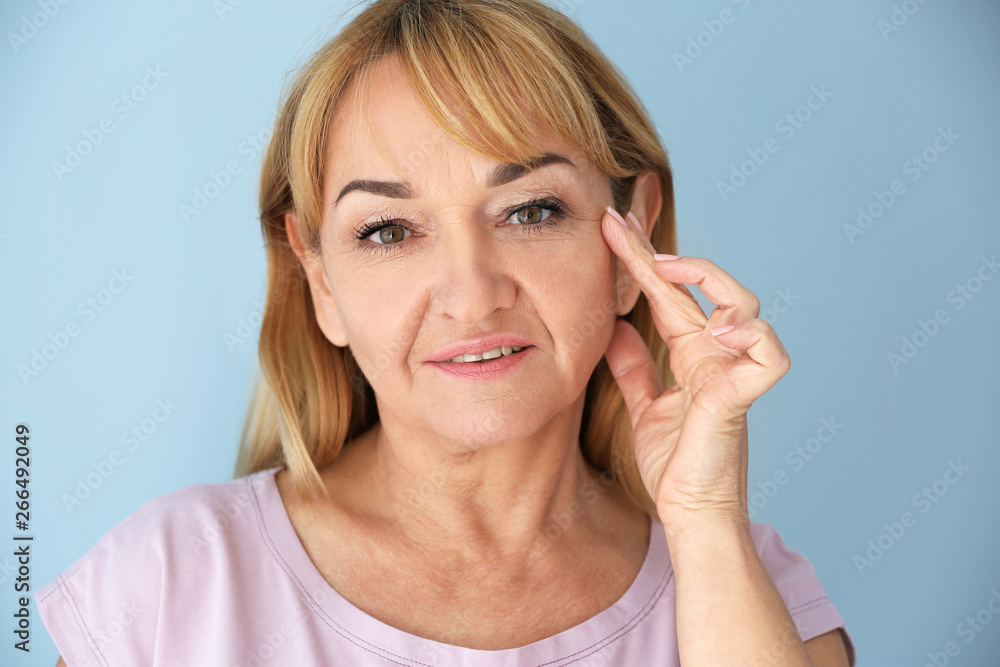 Mature woman with healthy skin on color background Mature woman with healthy skin on color background