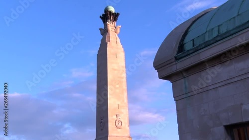 Tilt up reveal of the Portsmouth Naval War Memorial from the North West side against out building a blue sky at sunset on a clear day.