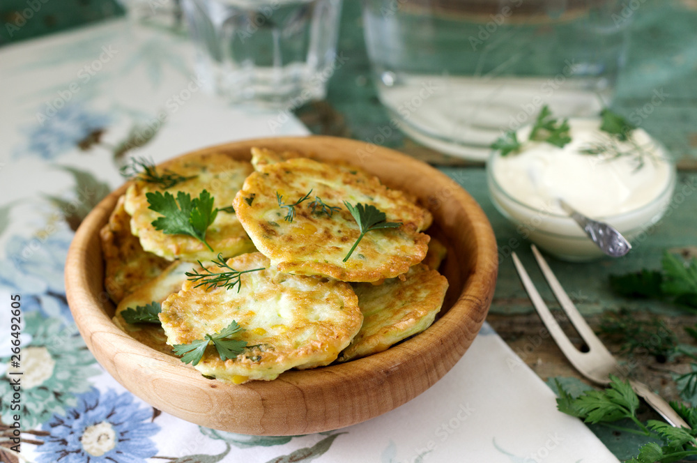 Pancakes with zucchini and sweet corn, served with sour cream, parsley and dill. Vegetarian food. Pancakes with zucchini and sweet corn, served with sour cream, parsley and dill. Vegetarian food.