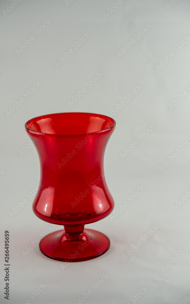 Single ruby red shot glass , white back ground Single ruby red shot glass , white back ground