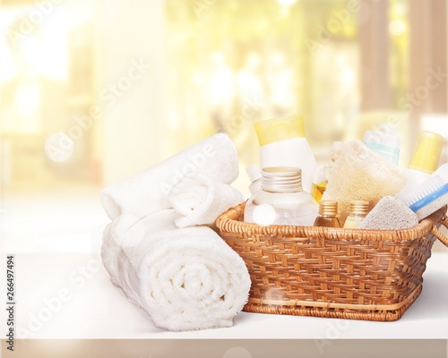 Bath towel and basket with accessories for spa on blur background