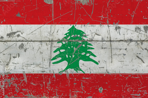 Grunge Lebanon flag on old scratched wooden surface. National vintage background.