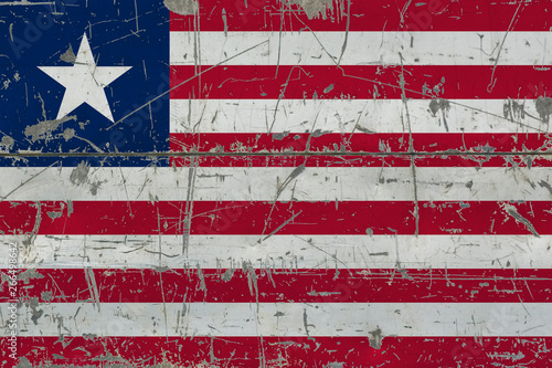 Grunge Liberia flag on old scratched wooden surface. National vintage background.