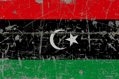 Grunge Libya flag on old scratched wooden surface. National vintage background. © sezerozger