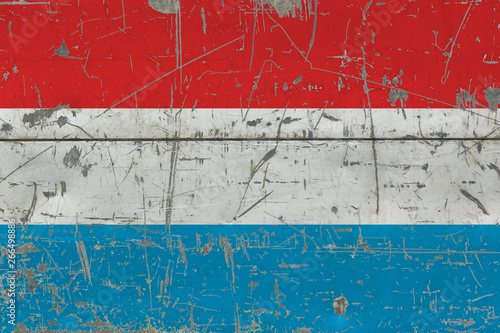 Grunge Luxembourg flag on old scratched wooden surface. National vintage background. © sezerozger