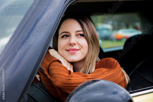 Woman sitting in a little car on a driver place