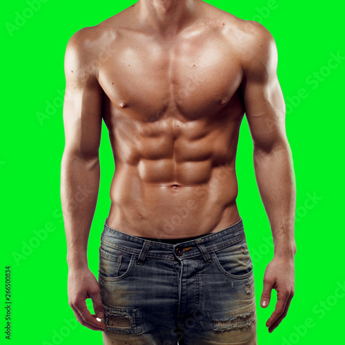 Fotografie Close up of a strong athletic muscled man in jeans standing on chroma key green background