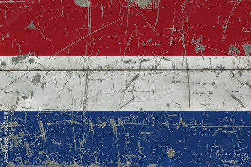 Grunge Netherlands flag on old scratched wooden surface. National vintage background. © sezerozger
