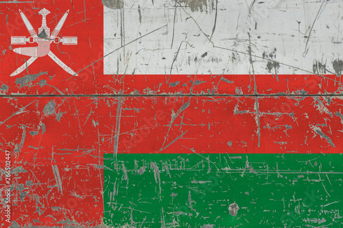 Grunge Oman flag on old scratched wooden surface. National vintage background. © sezerozger
