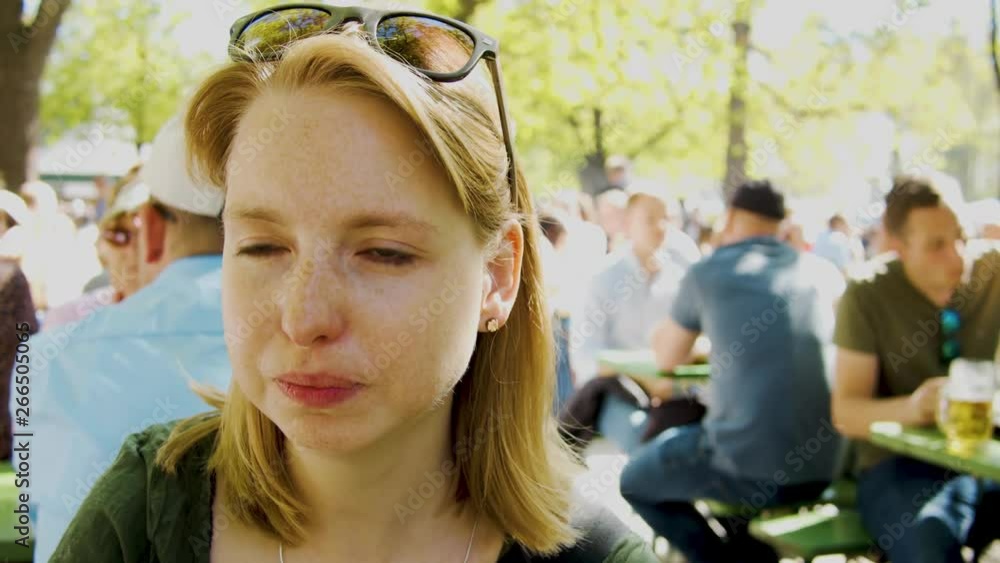 Woman drinks from glass in a crowded place Woman drinks from glass in a crowded place