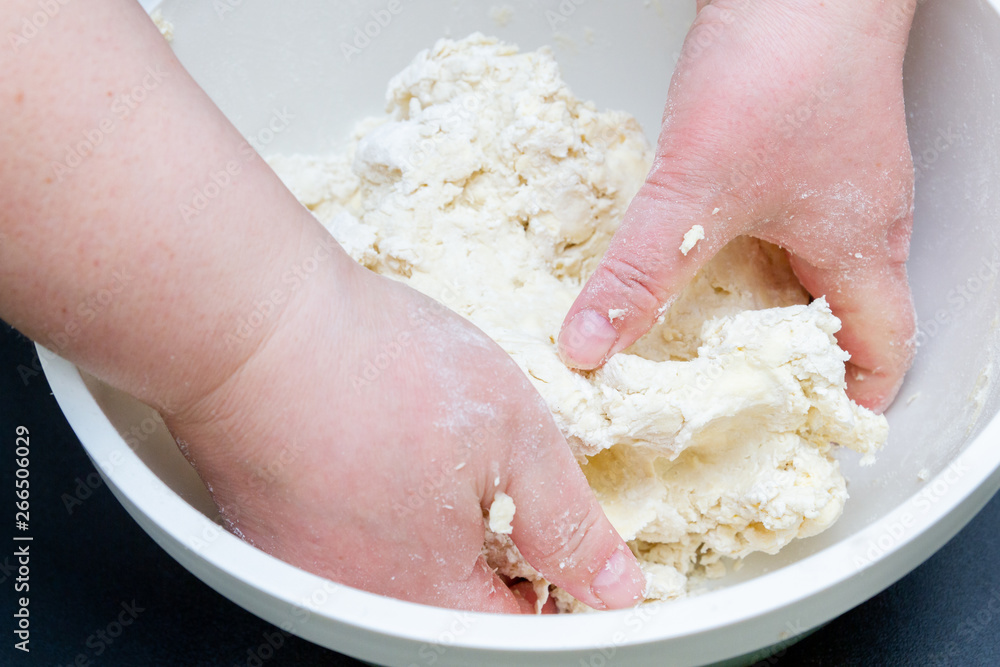 Mixing in a bowl of dough for the preparation of cottage cheese cookies Mixing in a bowl of dough for the preparation of cottage cheese cookies