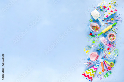 Sweet baking concept for birthday holiday party, cooking background with baking stuff - rolling pin, whipping whisk, cookie cutters, sugar sprinkling, flour. Light blue background, above copy space