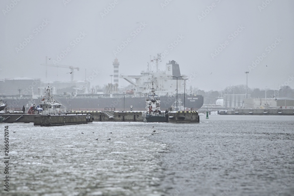 ferry trip in Lithuania to the city of Klaipeda in the winter season overlooking the bay with access to the Baltic Sea, and with cranes in the port