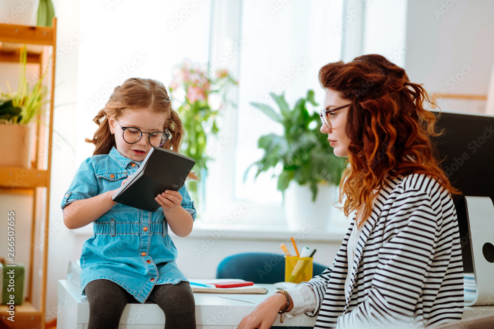 Mother and daughter wearing glasses spending time in office Mother and daughter wearing glasses spending time in office