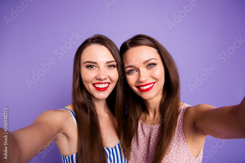 Close up photo two beautiful funny funky she her models ladies best buddies bonding perfect sunny weather make take selfies red lips toothy wearing summer dresses isolated purple violet background