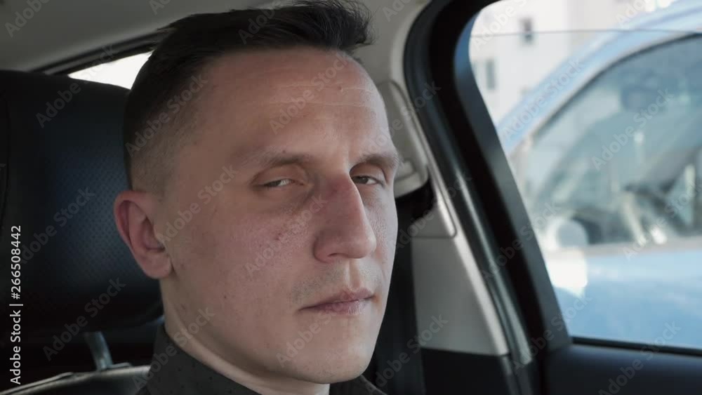 Portrait of a man sitting in a car. He looks at the camera. Portrait of a man sitting in a car. He looks at the camera.